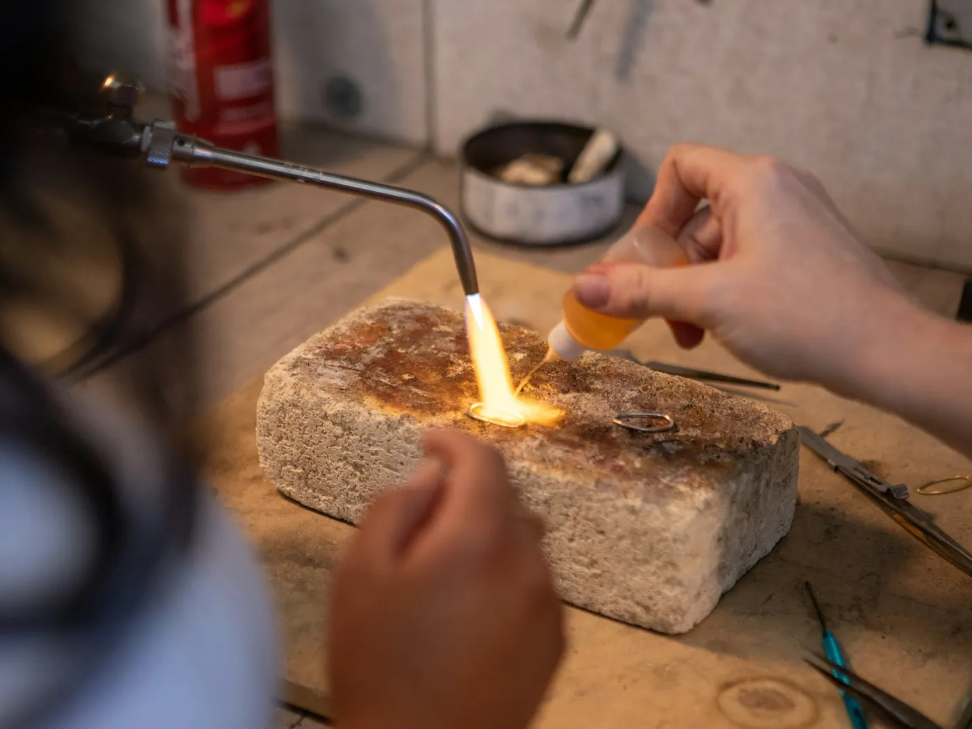 A goldsmith soldering a ring with a torch